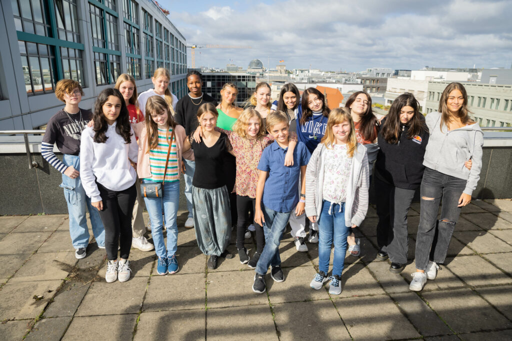 Gruppenfoto von 17 der Kinder- und Jugendbotschafter-/innen auf einer Dachterrasse.